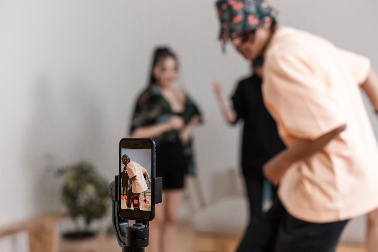 Vibrant indoor scene of people dancing recorded on a smartphone for a social media platform.