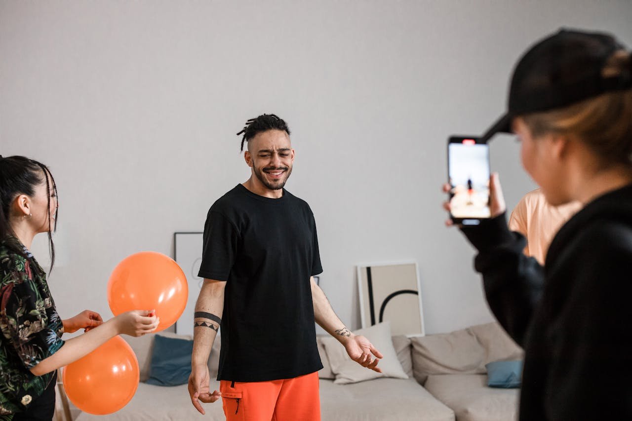 A group of friends filming a playful TikTok dance video indoors, capturing joy and creativity.